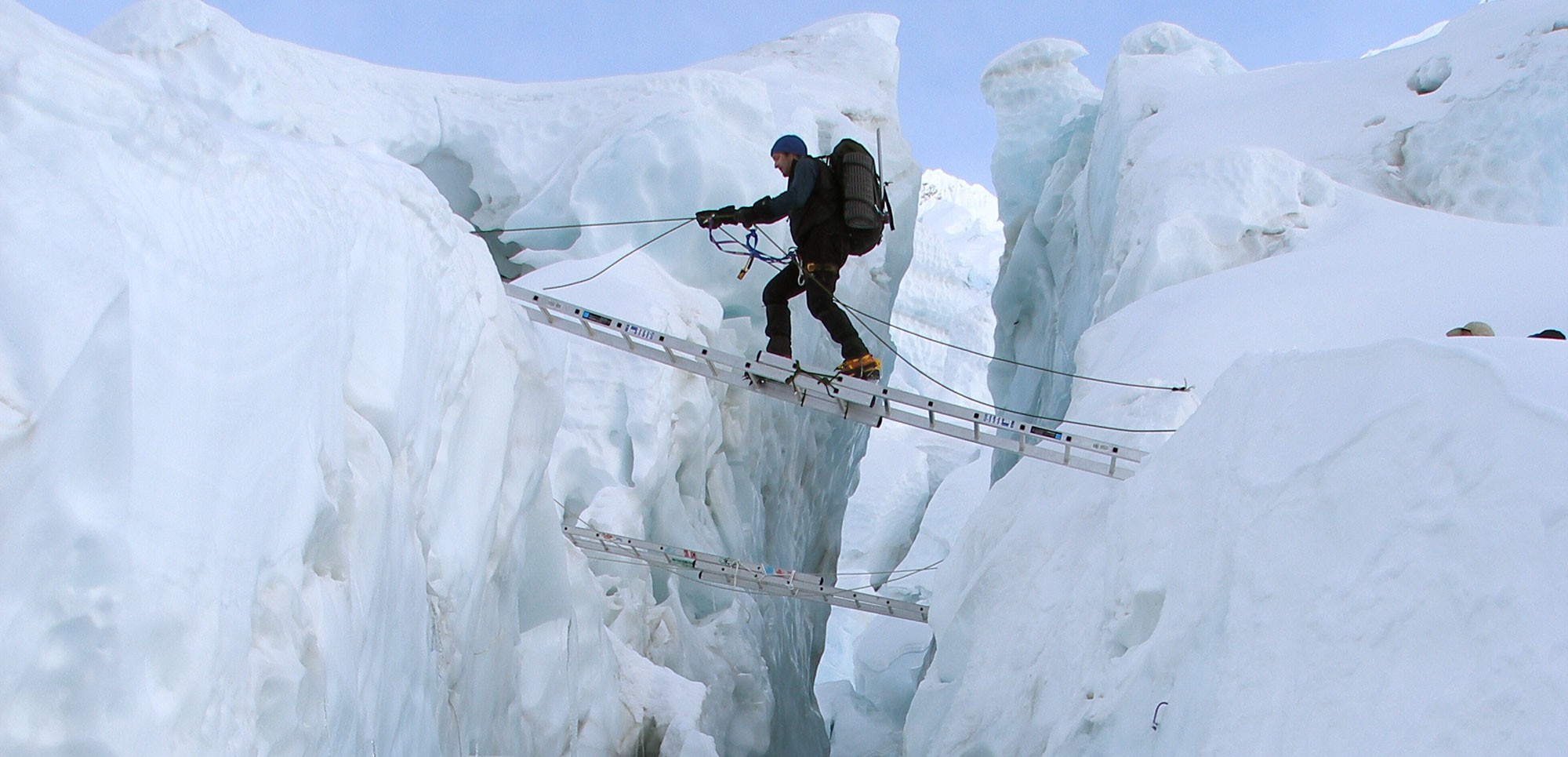 Tom Clowes crossing a crevasse in the Khumbu Icefall on Everest